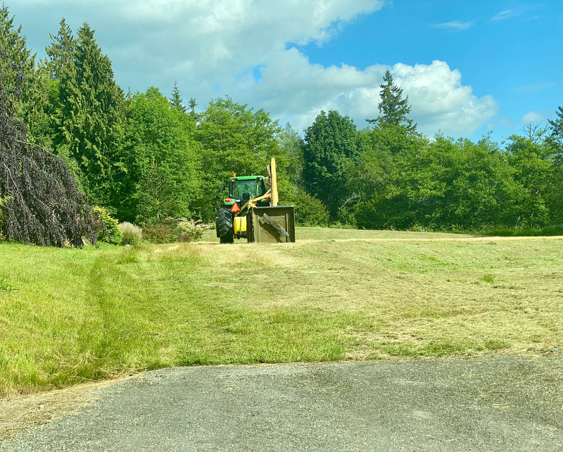 Licensed contractor's tractor mowing the neighborhood green space in Cedar Ridge Estates, Mount Vernon, WA, ensuring safe and professional maintenance.